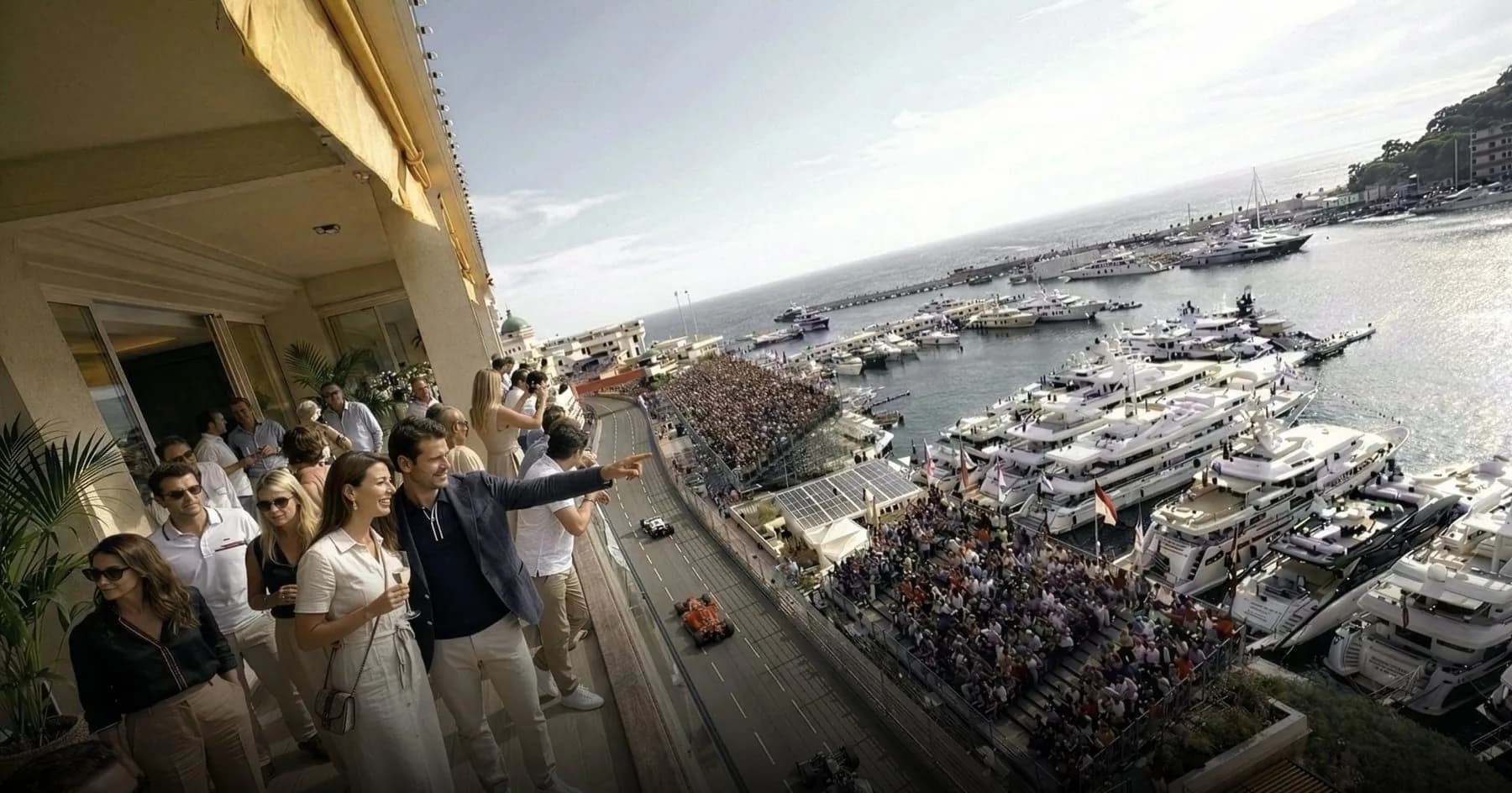 Guests on a balcony watching the circuit and Monaco's harbour during the Grand Prix